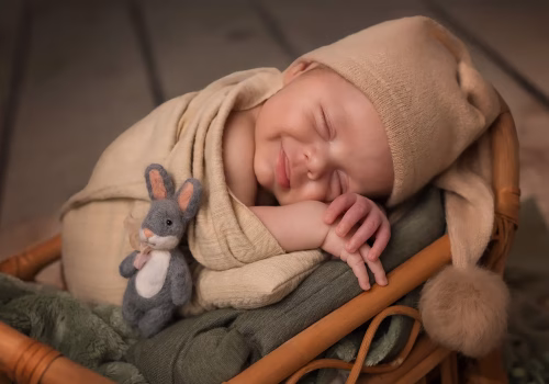 photo de bébé en studio dans un berceau en bois dans les tons naturels